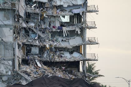 ARCHIVO - Una lona gigante en la parte inferior de la imagen cubre una sección de escombros en el edificio de condominios Champlain Towers South, en Surfside, Florida, el 4 de julio de 2021. (AP Foto/Lynne Sladky, Archivo)