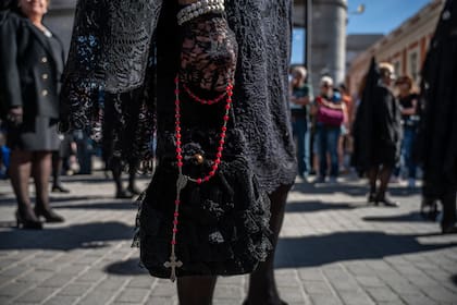 Archivo.- Una mujer con ropa tradicional de Pascua es vista llevando un rosario durante la procesión de la Soledad del sábado de Pascua