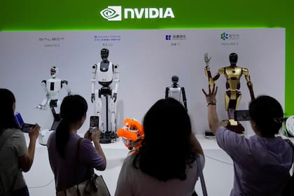 ARCHIVO - Visitantes dan órdenes a un robot en un puesto de Nvidia durante la 3ra Feria Internacional de China sobre Cadena de Suministro en el China International Exhibition Center, Beijing, el 18 de julio de 2025. (AP Foto/Mahesh Kumar A., Archivo)