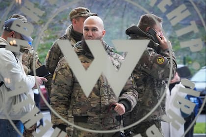 ARCHIVO - Visitantes vestidos con ropa de camuflaje militar en la entrada del "Centro Wagner PMC", vinculado al empresario y fundador del grupo militar privado Wagner, Yevgeny Prigozhin, durante la apertura del bloque de oficinas durante el Día de la Unidad Nacional, en San Petersburgo, Rusia, el viernes 4 de noviembre de 2022. (AP Foto, Archivo)