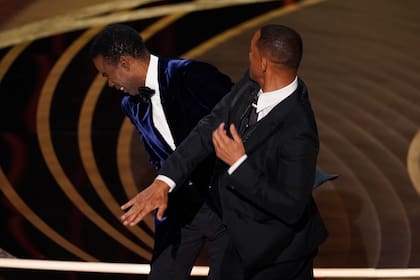 ARCHIVO - Will Smith, derecha, da una bofetada al presentador Chris Rock en el escenario de los Oscar en Los Angeles el 27 de marzo de 2022, después de que Rock hizo un chiste sobre la apariencia de su esposa Jada Pinkett Smith.  (Foto AP/Chris Pizzello, archivo)