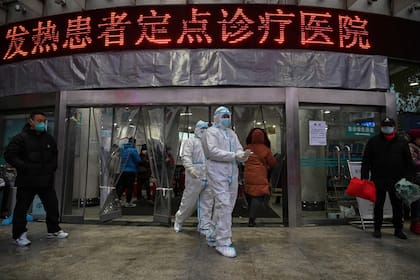 (ARCHIVOS) Esta foto de archivo tomada el 25 de enero de 2020 muestra a miembros del personal médico con ropa protectora en el Hospital de la Cruz Roja de Wuhan en Wuhan, mientras la ciudad luchaba contra el brote del otrora misterioso virus que finalmente mató a millones de personas en todo el mundo.