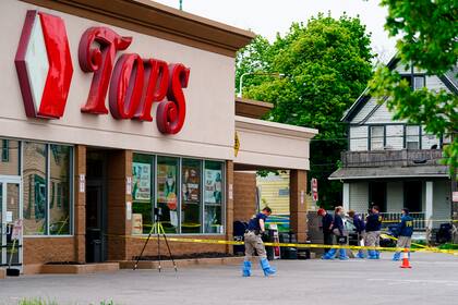 ARCHIVOS - Investigadores trabajan en la escena de una masacre en un supermercado en Buffalo, Nueva York, 16 de mayo de 2022. Un hombre blanco de 18 años mató a tiros a 10 clientes negros. (AP Foto/Matt Rourke, File)
