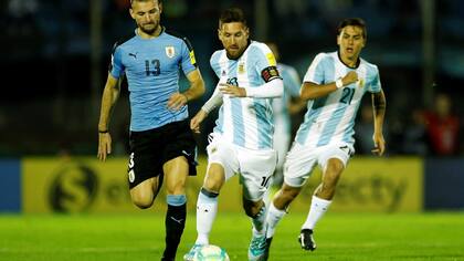 Lionel Messi, capitán argentino, deja atrás a Gastón Silva, de Uruguay. El clásico del Río de la Plata por las eliminatorias, previsto para el próximo 26 de marzo, podría postergarse.