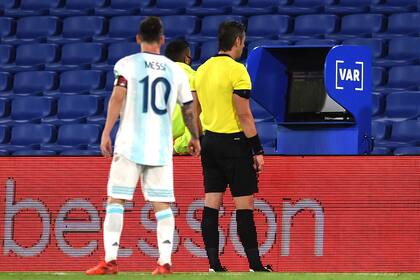 Lionel Messi espía cómo Raphael Claus observa la revisión de la jugada de su gol, que no será convalidado.