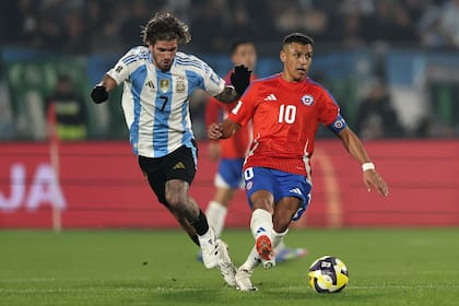 El centrocampista argentino Rodrigo De Paul y el delantero chileno Alexis Sánchez disputan el balón durante el partido de clasificación sudamericana para la Copa Mundial de la FIFA 2026 entre Chile y Argentina en el estadio Nacional Julio Martínez Pradanos en Santiago
