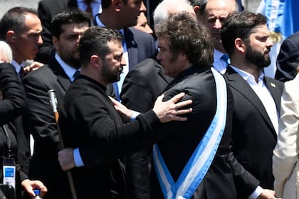 Argentina's new president Javier Milei (R) is greeted by Ukraine's President Volodymyr Zelensky after delivering his inaugural speech before the crowd during an inauguration ceremony at the Congress in Buenos Aires on December 10, 2023. Libertarian economist Javier Milei was sworn in Sunday as Argentina's president, after a resounding election victory fuelled by fury over the country's economic crisis. (Photo by Luis ROBAYO / AFP)�