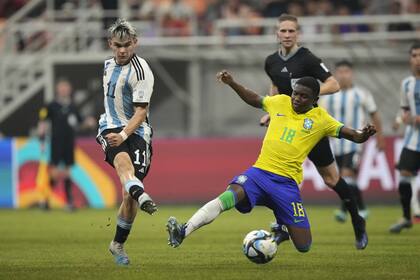 Argentina's Santiago Lopez, left, battles for the ball against Brazil's Sidney during their FIFA U-17 World Cup quarterfinal soccer match at Jakarta international Stadium in Jakarta, Indonesia, Friday, Nov. 24, 2023. (AP Photo/Achmad Ibrahim)