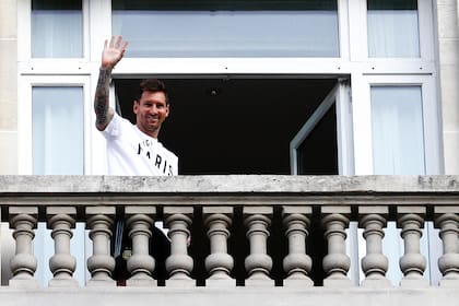 Argentinian football player Lionel Messi waves at fans from a balcony of the Royal Monceau hotel in Paris on August 10, 2021, as the football legend is expected to sign an initial two-year deal with Paris Saint-Germain football club following his departure from boyhood club Barcelona. (Photo by Sameer Al-DOUMY / AFP)