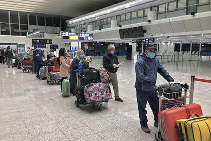 Argentinos varados en Italia, en la cola para chequeo médico en el aeropuerto de Fiumicino, en una postal inédita