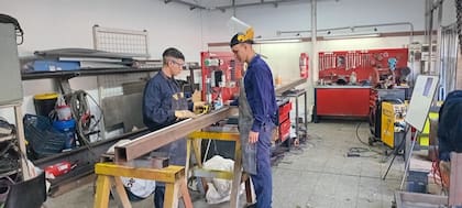 Ariel e Iván en la empresa de servicios para industrias Lenor, en Villa Ortuzar, donde ahora trabajan