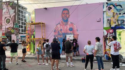 Arlex lleva a cabo su arte, la gente que pasea por el distrito de Wynwood, donde está el mural, lo mira
