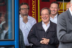 Armin Laschet (centro) rie mientras el presidente alemán (no visible) pronuncia un discurso después de que visitaron el centro de control de incendios y rescate de Rhein-Erft y en Erftstadt, en el oeste de Alemania