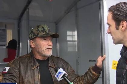 Arnold Schwarzenegger da una entrevista en la puerta de uno de los refugios en el campamento de veteranos