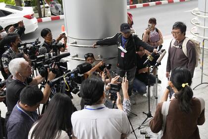 Arnon Nampa, a la derecha, habla con los medios de comunicación a su llegada al Tribunal Penal para escuchar el primer veredicto de su juicio, el martes 26 de septiembre de 2023.(AP Photo/Sakchai Lalit)