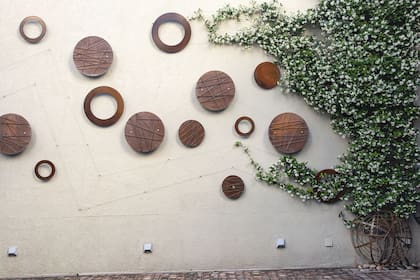 Aros y círculos de chapa de 2 mm de espesor decoran la medianera en conjunto con el verde