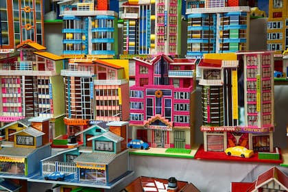 Las alasitas son miniaturas artesanales producidas con la finalidad ritual de que se conviertan en realidad. Varias emulan edificios de Mamani, reflejo del lugar aspiracional que ocupan hoy.
