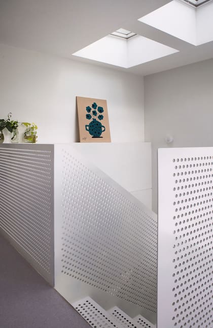 Arriba del hueco de la escalera, dos ventanas de techo Velux con panel solar se abren y cierran solas según el clima.