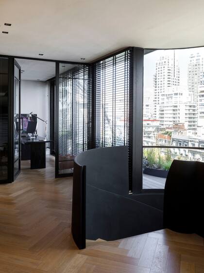 Arriba se ubicó el espacio de trabajo del dueño de casa, con cerramiento vidriado y escritorio enchapado en paraíso lustrado a poro abierto (Estudio Cali Herrera).