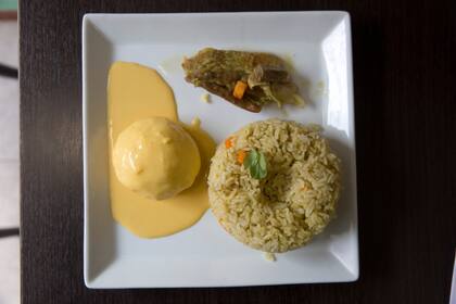 Arroz con especias, cerdo y una causa con crema huancaína