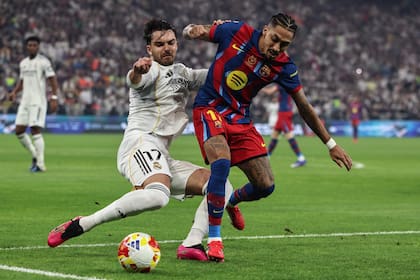 Asencio y Raphinha disputan un balón