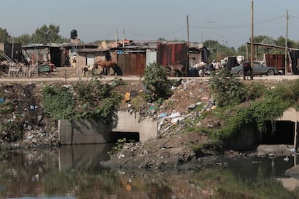 Asentamientos precarios junto a las sucias márgenes y las aguas fétidas; postal del Riachuelo