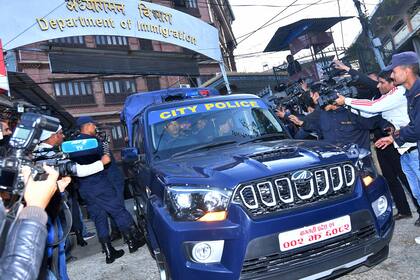 Un vehículo policial que se cree que transporta al asesino en serie francés Charles Sobraj es fotografiado mientras sale de la oficina de inmigración y se dirige al aeropuerto internacional de Tribhuvan en Katmandú el 23 de diciembre de 2022.