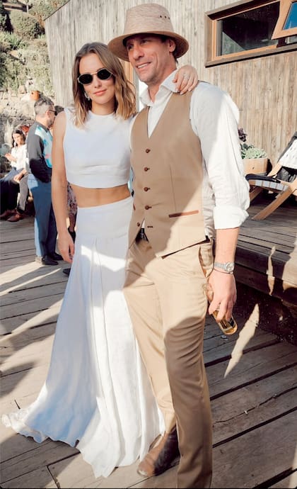 Asesorada por la estilista Sara Lavin, la novia lució un vestido de dos piezas diseñado por Daniela Bustamante, mientras que el novio optó por un traje color marrón (saco, pantalón y chaleco), camisa blanca y sombrero.