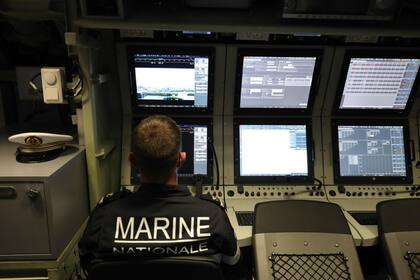 Un oficial de la marina francesa mira las pantallas en el centro de navegación y operaciones del nuevo submarino nuclear