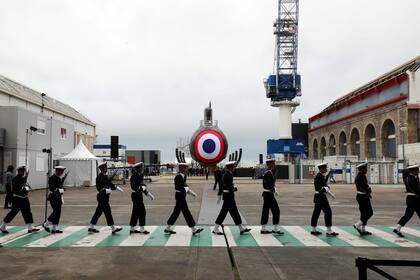 Miembros de la Infantería de Marina Nacional francesa desfilan frente al nuevo submarino nuclear llamado "Suffren" en el astillero del Grupo Naval en Cherbourg, en el noroeste de Francia