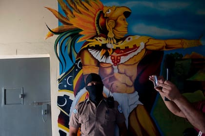 Un guardia junto a un mural en la prisión de Quezaltepeque, en El Salvador