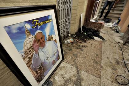 Una foto del papa Francisco en medio de los destrozos