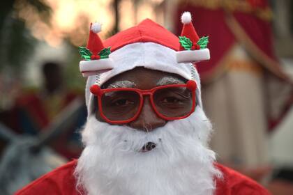 Un hombre haitiano disfrazado de Papá Noel participa en un desfile navideño en Petion Ville, en la capital haitiana de Puerto Príncipe