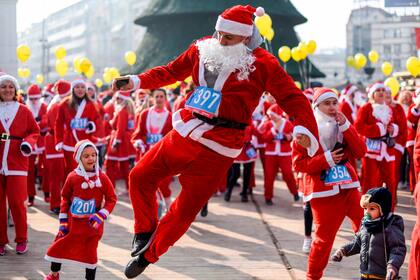 La gente vestida como Papá Noel baila y se prepara para la carrera anual de la ciudad en Skopje, Macedonia