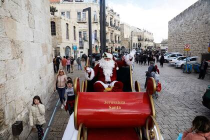 Un hombre vestido de Papá Noel pasea por las calles de Jerusalén