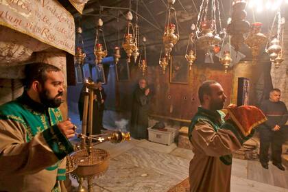 Los fieles cristianos armenios oran dentro de la Gruta, el lugar donde se cree que nació Jesucristo, en Cisjordania 