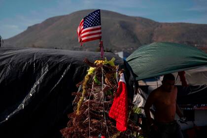 Un improvisado árbol de Navidad con bandera norteamericana en el refugio temporal de migrantes, en Baja California, México