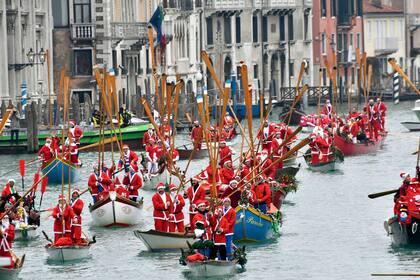Residentes de Venecia navegan disfrazados por el Gran Canal de Venecia, a bordo de las góndolas