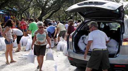 Los vecinos juntan bolsas de arena para contener el agua que se espera suba a niveles inusuales