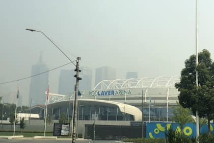 En primer plano, el Rod Laver Arena; detrás, los edificios casi ocultos por el smog de Melbourne.