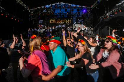 Los turistas bailan frente al escenario mayor de la Oktoberfest