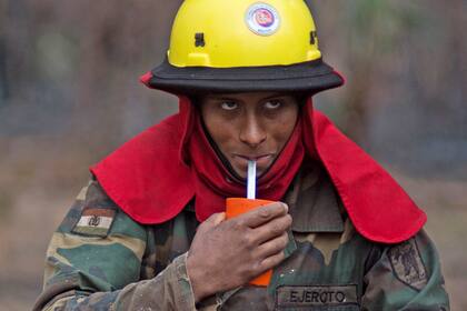 Un soldado boliviano que ayuda a combatir los incendios se refresca durante un descanso