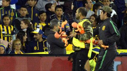 Asistentes de Rosario retiran los muñecos para que pueda continuar el partido