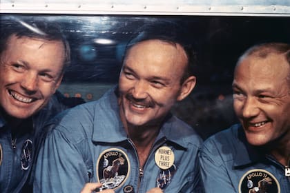 Astronautas del Apolo 11 (de izquierda a derecha): Neil Armstrong, Michael Collins y Buzz Aldrin miran desde la ventana de sus habitaciones de aislamiento a bordo del U.S.S. Hornet después de su recuperación el 24 de julio.