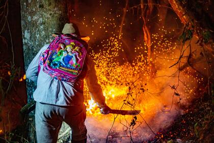 David, un baqueano de la comunidad San Ignacio, en Salta, combate a machetazos el fuego para impedir que llegue a los hogares; foto de Javier Corbalán
