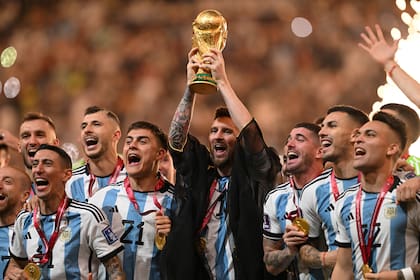 Lionel Messi, rodeado por sus compañeros, levanta la Copa del Mundo.