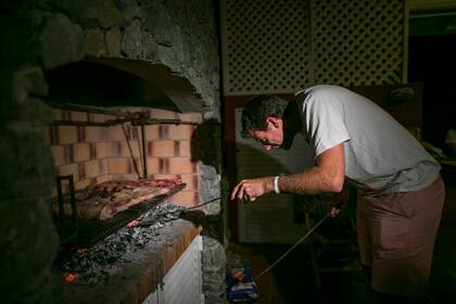 Atento al fuego del asado, en la noche de Cariló