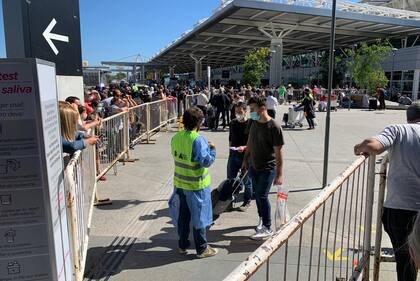 Las personas que esperan a los pasajeros no pueden entrar al aeropuerto y deben esperar afuera detrás de una valla