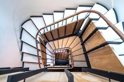 Aunque la propiedad cuenta con un ascensor, las escaleras caracol recorren los tres pisos y le dan un troque especial al diseño de la casa