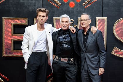 Austin Butler, el director Baz Luhrmann y Tom Hanks, de izquierda a derecha, posan al llegar al estreno de Elvis en Londres el martes 31 de mayo de 2022. (Foto por Vianney Le Caer/Invision/AP)
